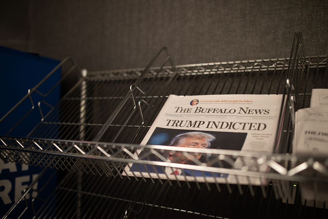 An issue of The Buffalo News sits on a newsstand, with a headline reading TRUMP INDICTED above a picture of Donald Trump.
